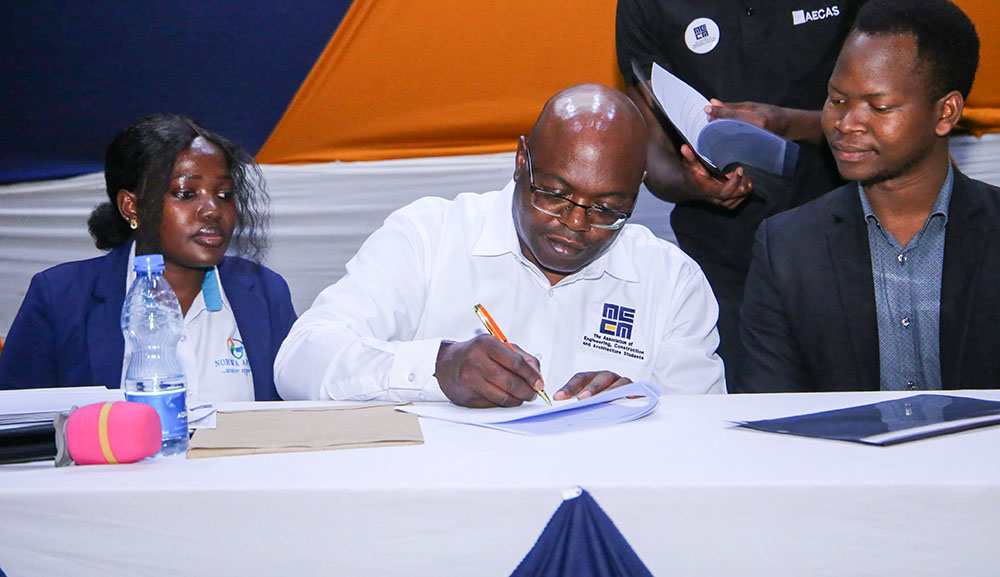 Dr.Joseph Kedogo, AECAS Patron, signing the MoU. Looking on is Ms. Charity Bright and Swahib Asma from Norwa Africa